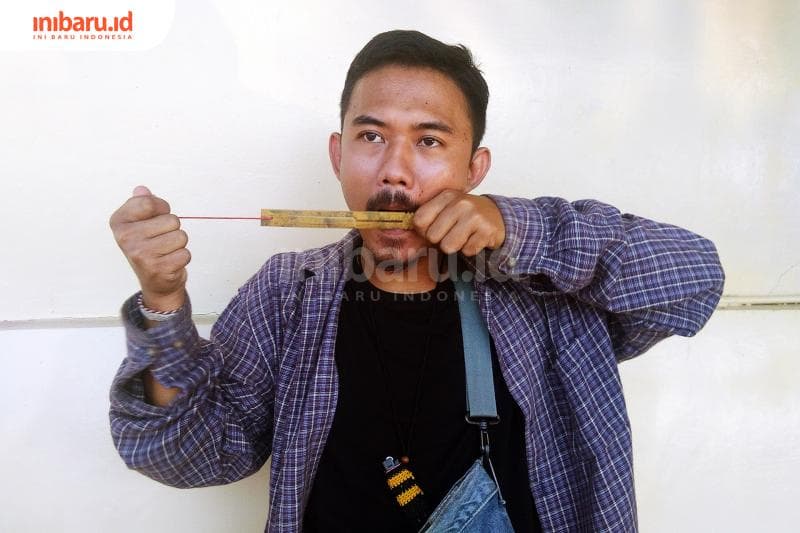 Iwenk melestarikan harpa rahang bambu. (Inibaru.id/ Isma Swastiningrum)