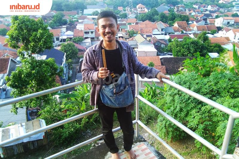 Iwenk dengan harpa rahang bambu hasil buatannya. (Inibaru.id/ Isma Swastiningrum)