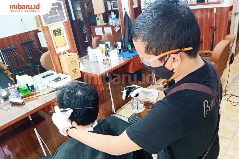 Proses potong rambut dengan APD sederhana. (Inibaru.id/ Zulfa Anisah)