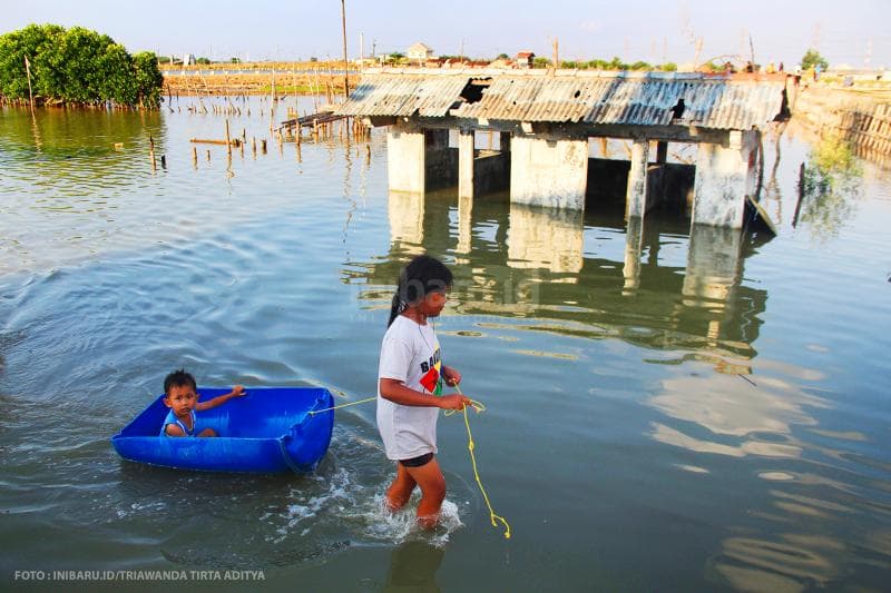 Anak-anak memanfaatkan banjir rob sebagai wahana permainan.<br>