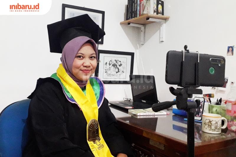 Wisudawan tengah bersiap mengikuti upacara wisuda daring Unnes dari kamarnya. (Inibaru.id/ Dyana Ulfach)