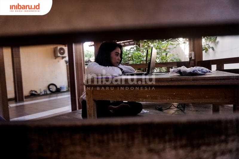 Dinna menyimak wisuda daring dari gazebo kos-kosan. (Inibaru.id/ Audrian F)<br>