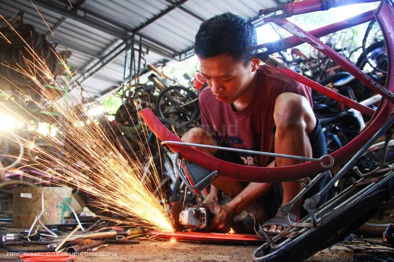 Teknisi bengkel sepeda X-San Bike mengelas rangka sepeda milik pelanggan.<br>