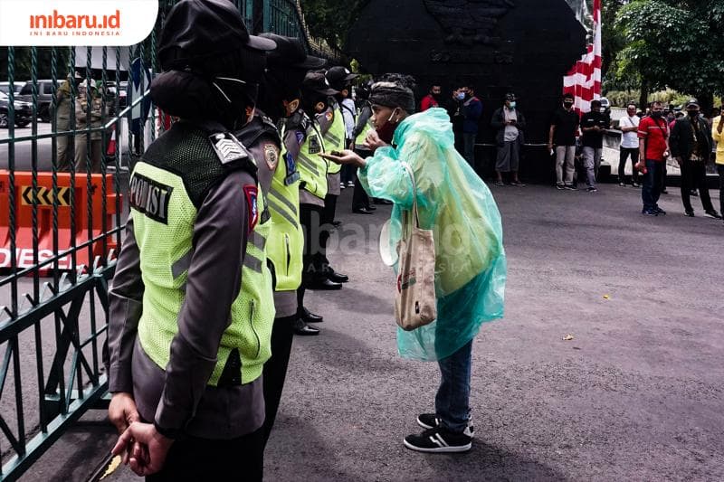 Seorang demonstran penolak Omnibus Law melakukan orasi di depan aparat keamanan. (Inibaru.id/ Audrian F)<br>