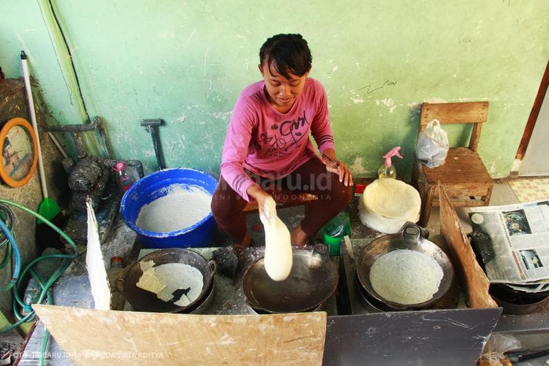 lumpia dituangkan ke atas adonan menggunakan tangan kosong<br>