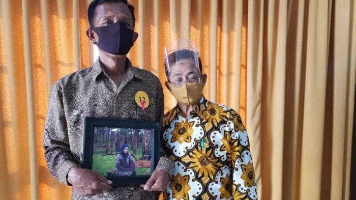 Buchori membawa foto anaknya saat wisuda. (Tribun Timur/Alfian)<br>
