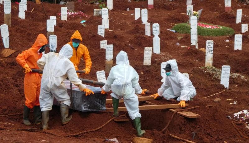 Ilustrasi: Petugas mengubur jenazah penderita Covid-19 di Jakarta pada 14 April 2020. (AFP/Bay Ismoyo)<br>