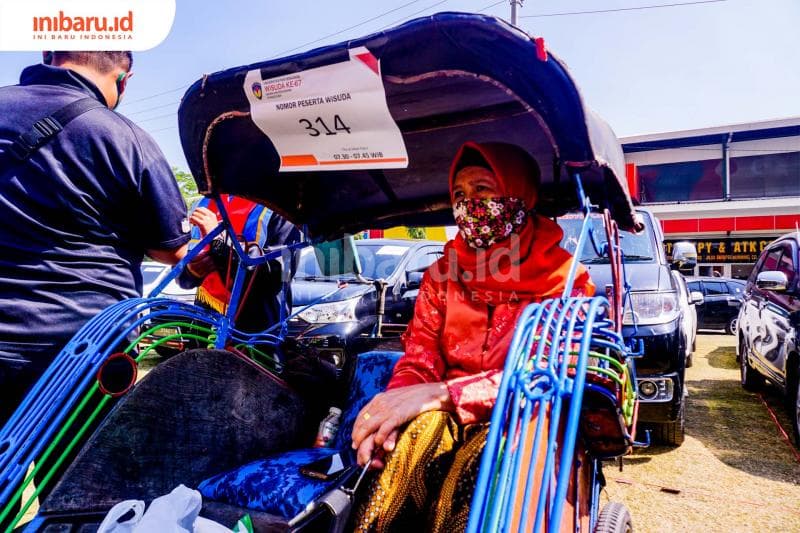 Ibu Musa, Trisna Dewi, ikut mengantarkan anaknya diwisuda dengan naik becak. (Inibaru.id/ Audrian F)<br>