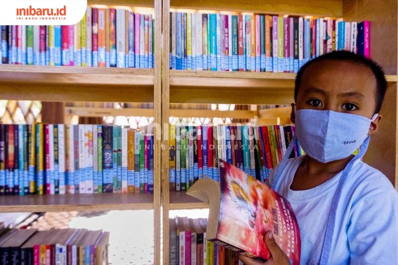 Seorang anak dan buku Isabel Allende. (Inibaru.id/ Audrian F)<br>