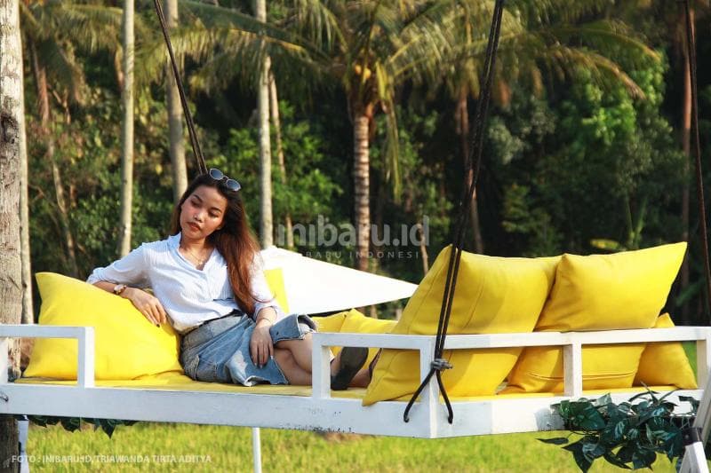 Sofa yang digantung di atas pohon kelapa ini bisa bikin kamu mager seharian.<br>