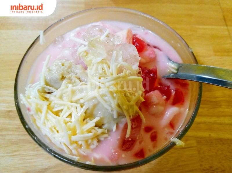 Seporsi Sop Duren Babeh Cheese berisi potongan puding, kelapa muda, santan, dan buah durian dengan toping parutan keju. (Inibaru.id/ Dwi Nastiti M)