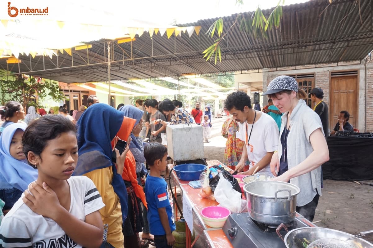 Pengunjung melihat seniman bule yang sedang memasak. (Inibaru.id/ Ida Fitriyah)