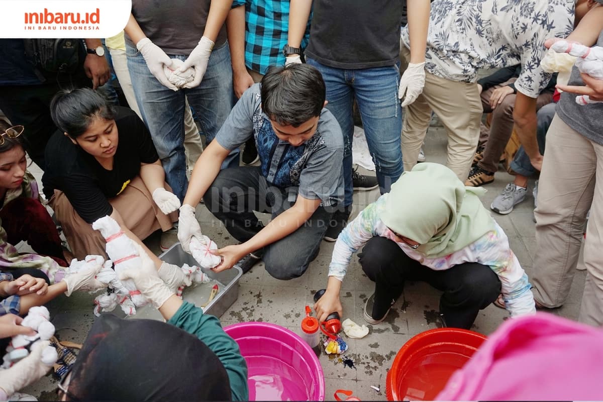 Pendiri Keikat, Rosita sedang menjelaskan teknik pewarnaan batik ikat celup kepada para peserta workshop tie dye, Sabtu (23/02/2019) di Impala Space. (Inibaru.id/ Ida Fitriyah)
