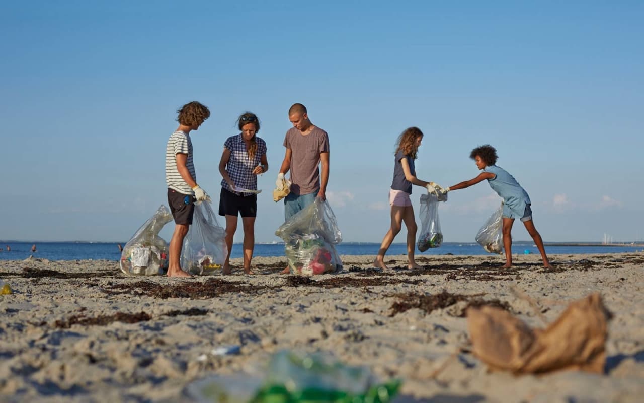 Sekelompok orang tengah memunguti sampah untuk mengikuti <em>#trash Challenge</em>. (getty Image)