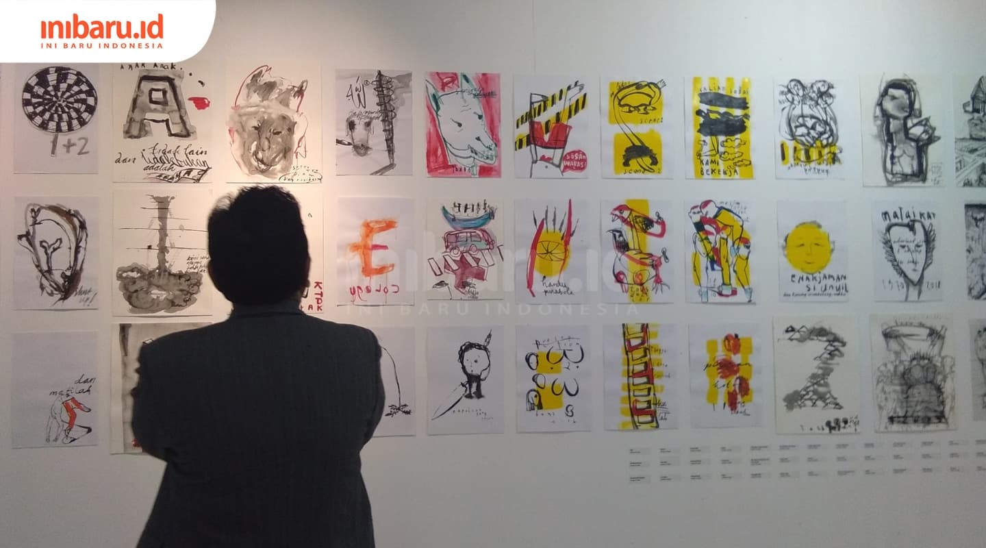 Pengunjung sedang melihat lukisan karya Kokoh Nugroho. (Inibaru.id/ Isma Swastiningrum)