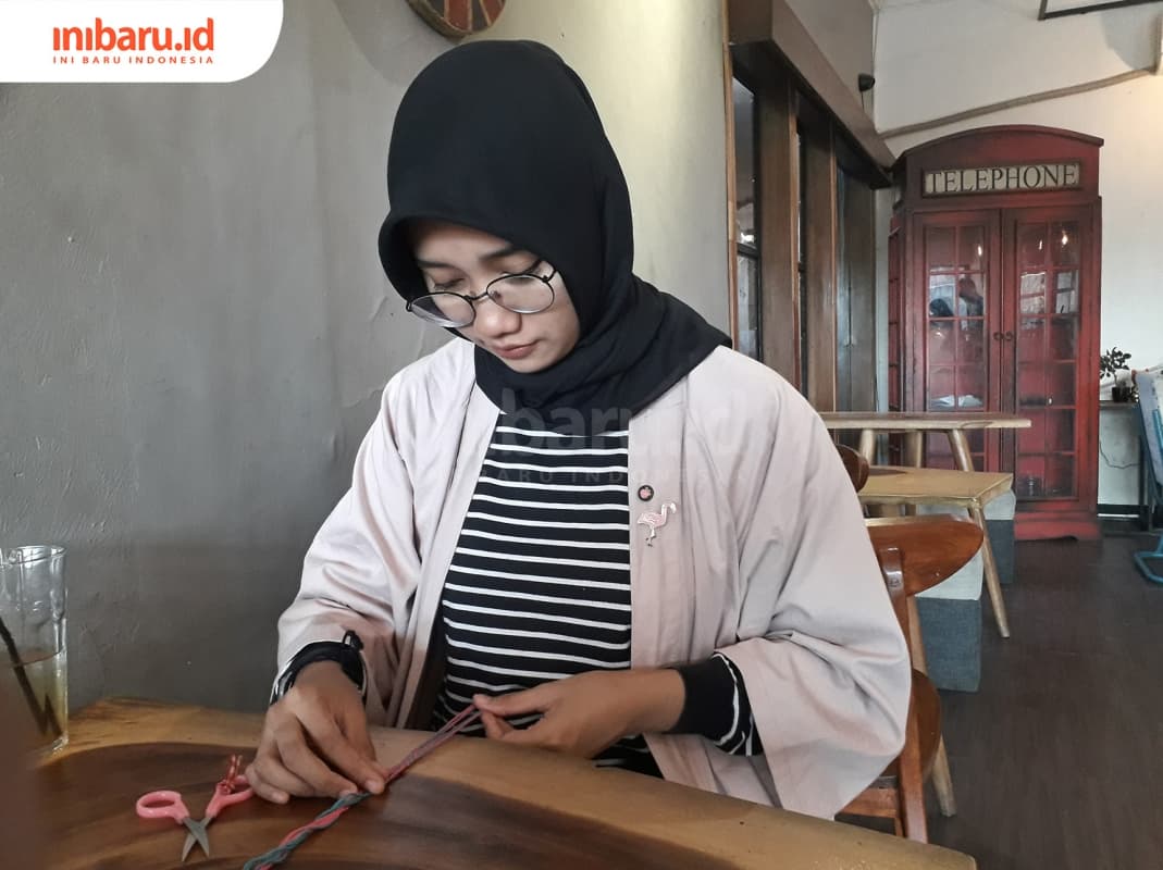 Zahra Rahmi, owner Pipi Merah sedang membuat gelang dengan teknik makrame. (Inibari.id/ Dyana Ulfach)
