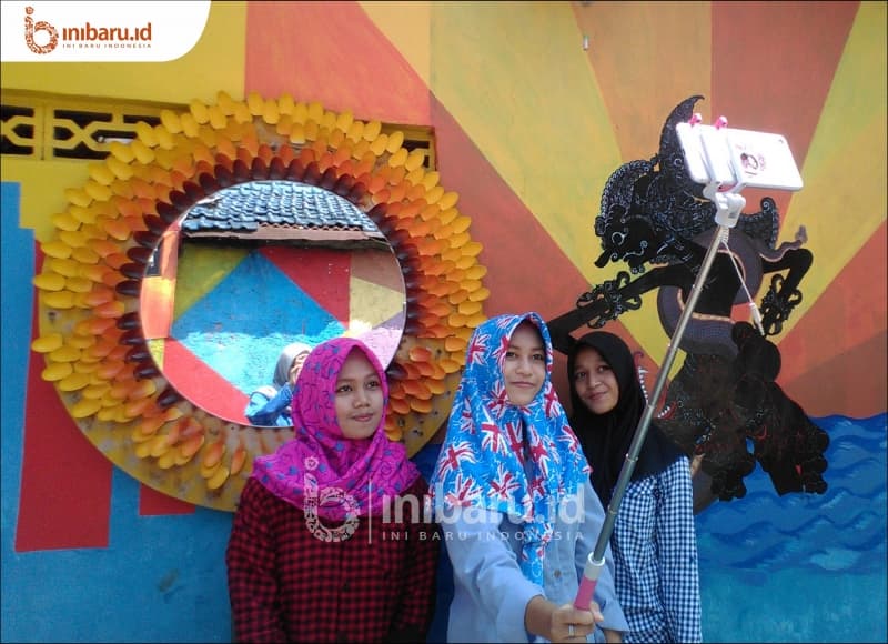 Pengunjung berswafoto di Kampung Pelangi. (Inibaru.id/Verawati Meidiana)