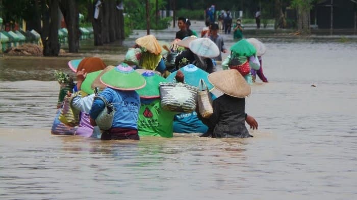 Warga melintas di jalan yang terendam banjir di Brebes. (Tribunnews.com)