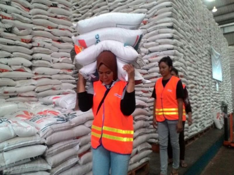 Memikul beras di gudang Bulog. (Kompas.com/Hendra Cipto)