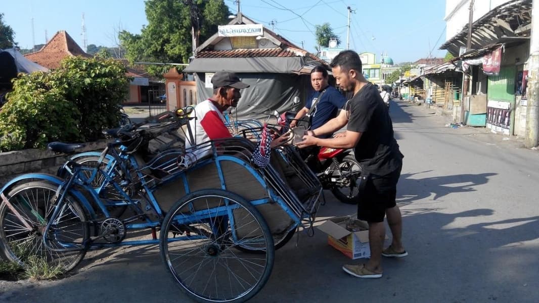Komunitas Sedekaholic saat membagikan nasi bungkus kepada masyarakat (beritagar.id)