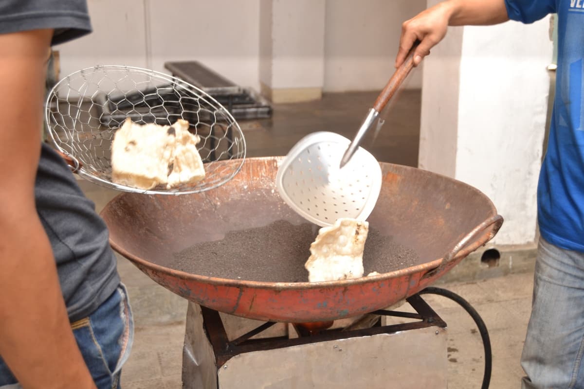 Ilustrasi menggoreng kerupuk dengan pasir. (Pinterest)