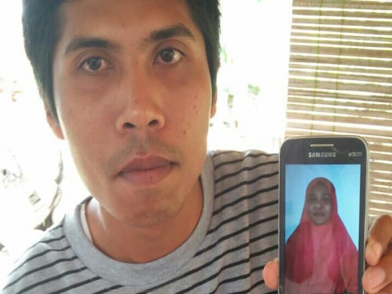 Zaenal Arifin menunjukkan foto istrinya, Usnawati, buruh migran asal Lombok Tengah yang “disasarkan” ke Suriah. (Kanalntb.com)