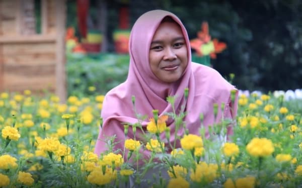 Salah satu pengunjung tengah berpose di antara bunga-bunga. (Wisatamagelang)