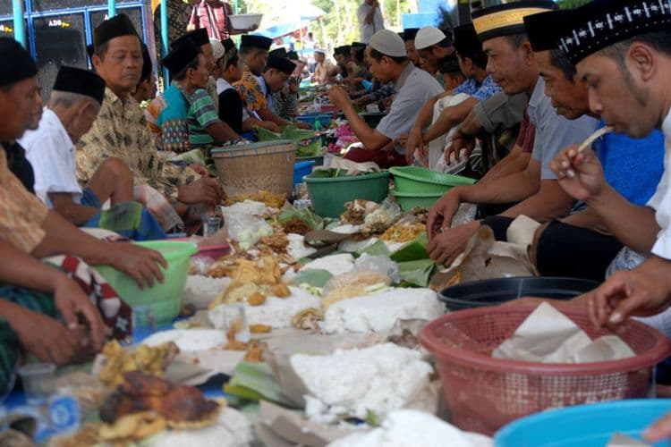 Warga Desa Guci sedang menikmati nasi ingkung saat tradisi Apitan berlangsung. (Kompas.com/PUTHUT DWI PUTRANTO)