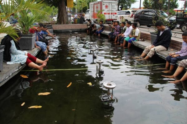 Pengunjung asyik menikmati terapi ikan di Masjid Al Aqsha Klaten. (soloraya.solopos.com) 