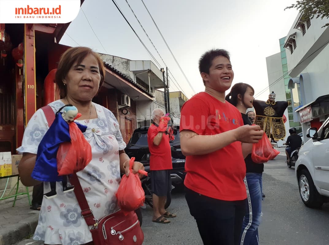 Sambil memegangi wayang, umat klenteng mencegat pengguna jalan untuk diberikan takjil. (Inibaru.id/ Zulfa Anisah)