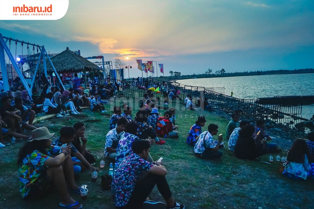 Para penonton "Pesta Pantai" menikmati  embusan angin laut saat matahari terbenam. (Inibaru.id/ Audrian F)
