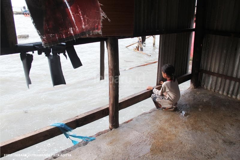 Seorang bocah di Tambaklorok mengamati situasi ombak dari rumah warga yang sudah hancur.<br>