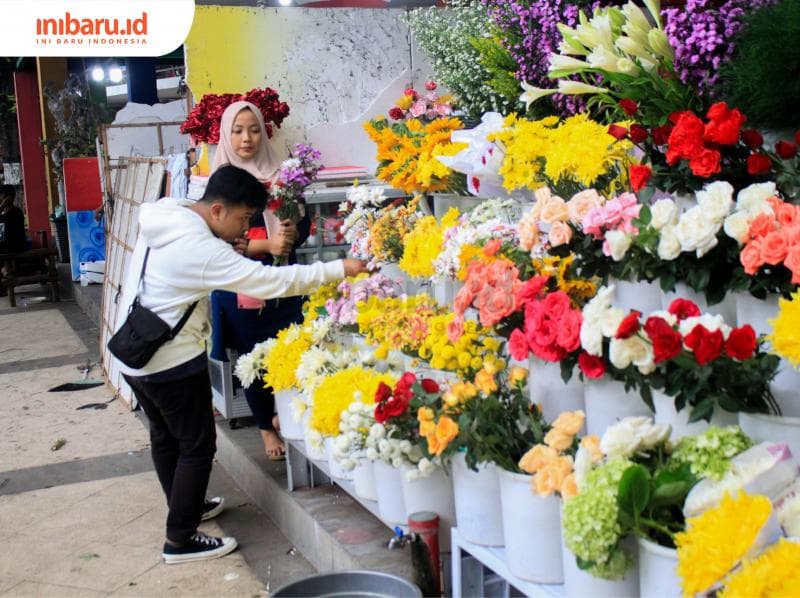 Salah seorang pedagang bunga di Pasar Bunga Kalisari sedang melayani pelanggan. (Inibaru.id/ Audrian F)