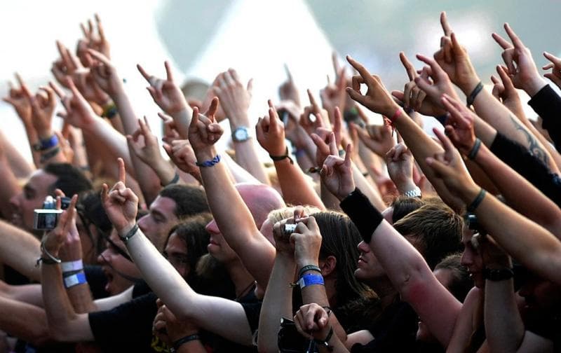 Penonton band metal mengacungkan simbol 'garpu metal'. (Tirto/Megainsane)