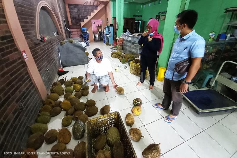 Pembeli mencicipi durian yang akan dibeli. Jika rasanya nggak cocok, durian boleh dikembalikan.<br>
