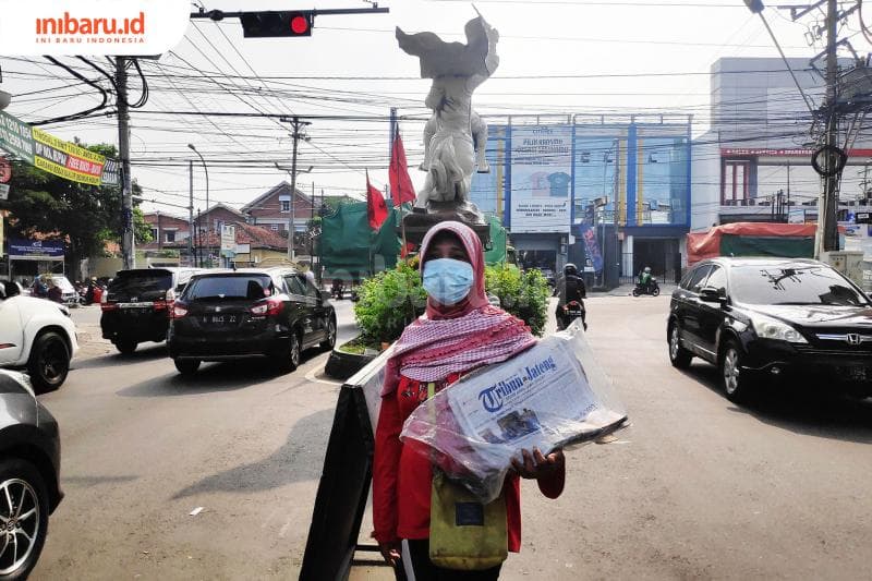 Di bawah Patung Diponegoro, Lestari senantiasa mengais rezeki dari koran-koran yang terbeli. (Inibaru.id/ Bayu N)