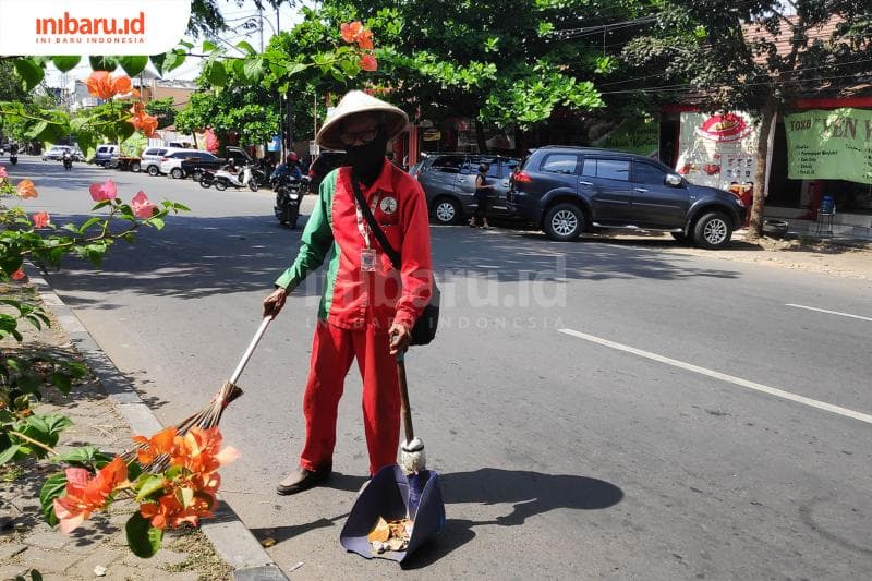 Pak Rohani, usia tujuh puluh masih tetap semangat membersihkan jalanan. (Inibaru.id/Bayu N)