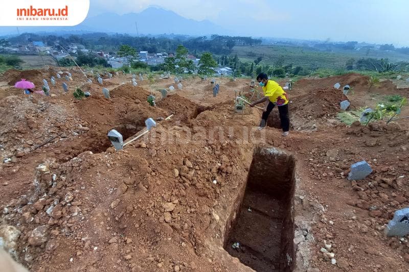 Seorang penggali kubur sedang melakukan pekerjaannya di makam korban Covid-19 di area Mijen Semarang. (Inibaru.id/Triawanda Tirta Aditya)