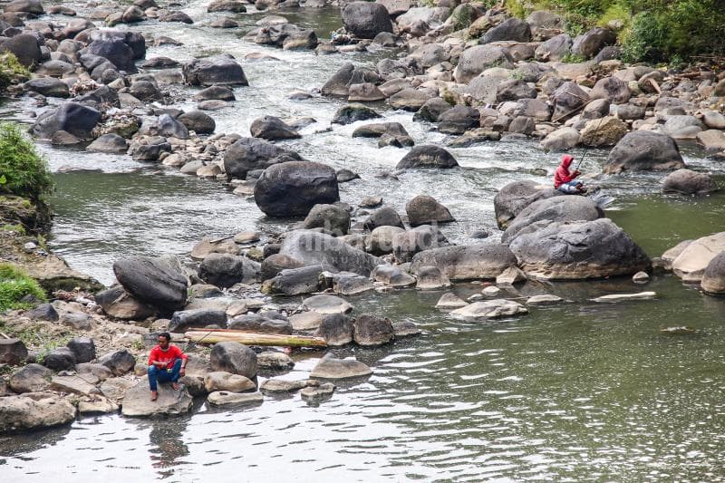 Dua pemancing asyik menunggu tarikan ikan di sungai Kaligarang.&nbsp;