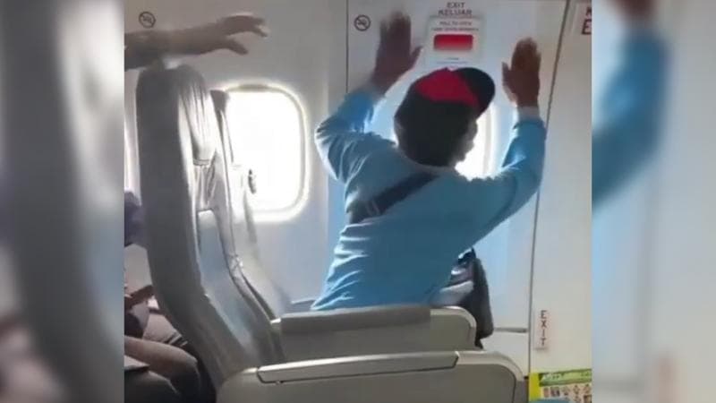 Kades Ngeblak Blora saat membuka pintu darurat pesawat. (riauin.com)