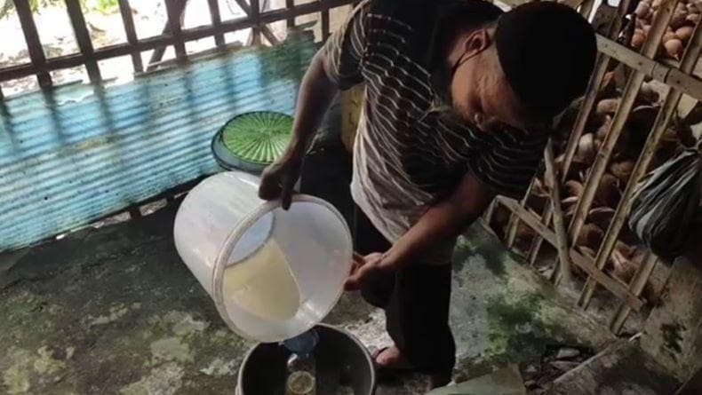 Dalikun saat membuat minyak kelapa di Kebumen. (Inews/Joe Hartoyo)