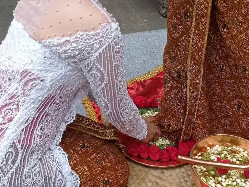 Membasuh kaki suami menjadi bukti bakti seorang istri. (Instagram/Adat Jawa Plenner)