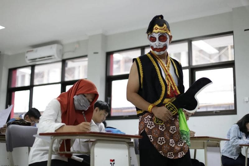 Ilustrasi: Pengawas berkostum Bawor lengkap dengan kudi di tangannya menjadi cara unik yang dilakukan sebuah sekolah di Banyumas untuk mengurangi ketegangan siswa. (Ittelkom-pwt)