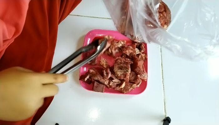 Tempatkan daging dalam wadah kedap udara sebelum dimasukkan ke dalam mesin pendingin. (Tangkapan layar youtube Bisnis Ibu rumah Tangga via Gorajuara)