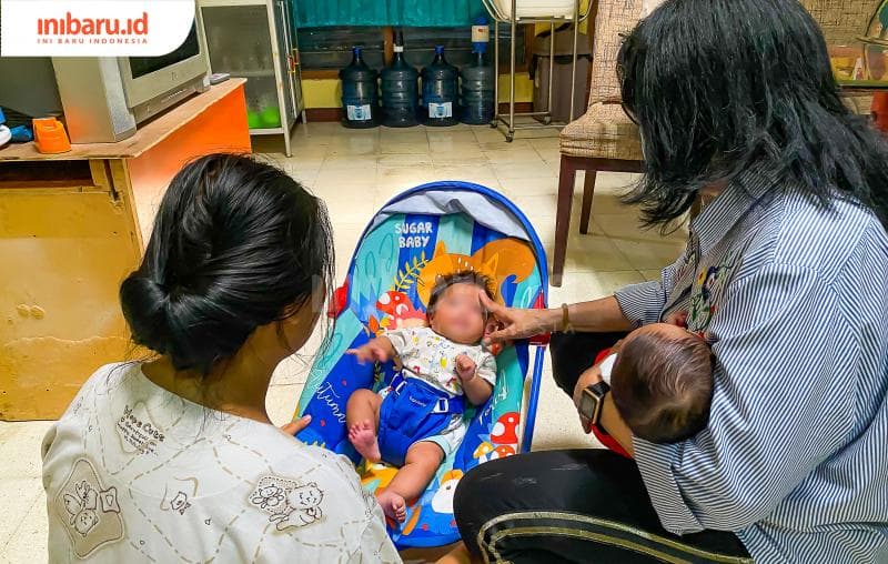 Rosalia Amaya menenangkan salah seorang bayi yang rewel.&nbsp;(Inibaru.id/ Kharisma Ghana Tawakal)