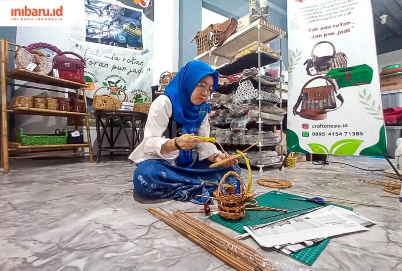 Owner&nbsp;Craftonesia Piliani Ernawati sedang menganyam koran bekas yang telah dipilin untuk dijadikan kerajinan tangan.&nbsp;(Inibaru.id/ Fitroh Nurikhsan)