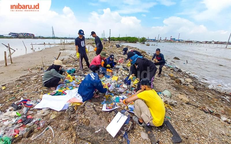 Sejumlah mahasiswa dan pegiat lingkungan sedang melakukan brand audit terhadap sampah yang mencemari kawasan bibir pantai Tambakrejo. (Inibaru.id/Fitroh Nurikhsan)