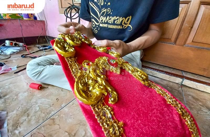 Adhe Pamungkas sedang menggarap kostum untuk keperluan karnaval Ratu Kalinyamat di Jepara. (Inibaru.id/ Fitroh Nurikhsan)
