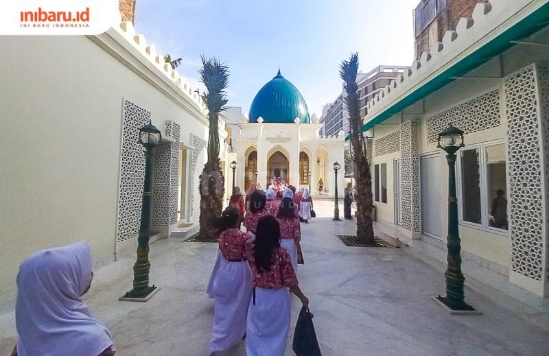 Siswa-siswi SD di Kelurahan Kembangsari tengah berjalan menuju makam utama Mbah Depok Semarang. (Inibaru.id/ Fitroh Nurikhsan)