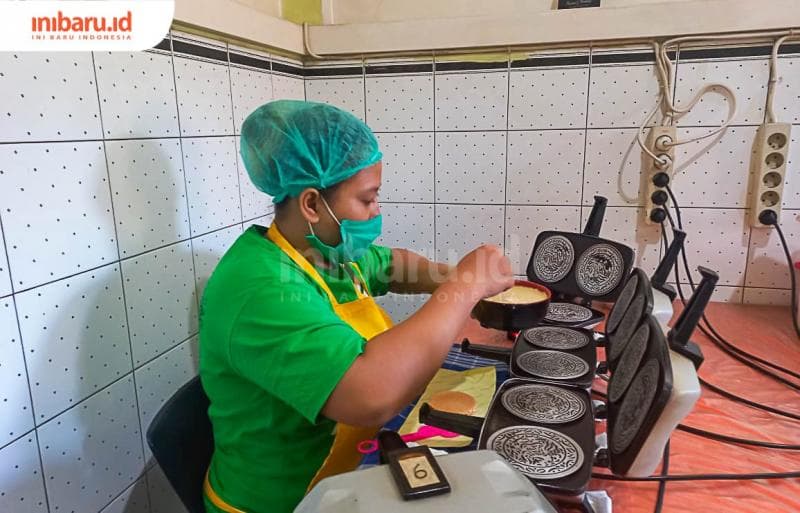 Seorang pegawai sedang mencetak adonan kue semprong. (Inibaru.id/ Fitroh Nurikhsan)